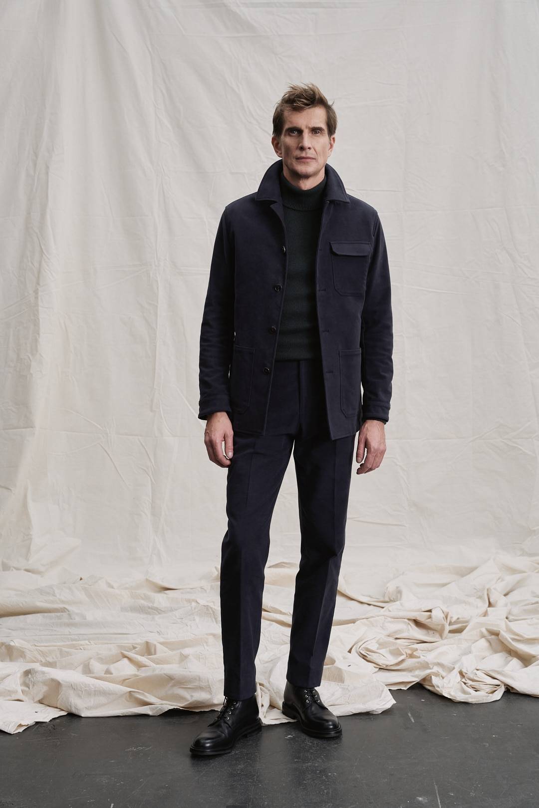 Detailansicht der feinen Strickstruktur des grünen Rollkragenpullovers